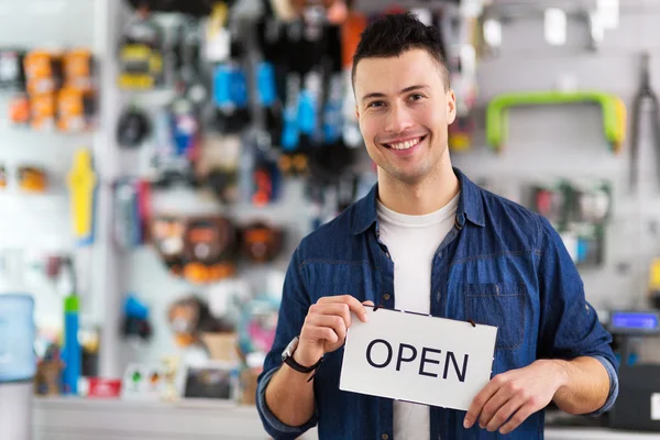 Man holding open sign in bike shop — Stock Photo, Image