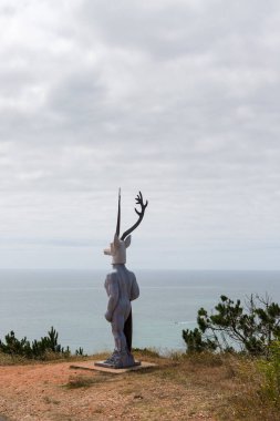 Nazare, Portugal - June 27, 2021: The famous statue of the deer surfer the surfista da Nazare.