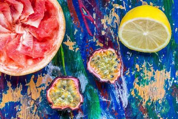 Passion frukt, citron och grapefrukt halvorna på en färgglad backgro Stockbild