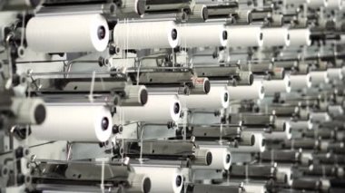 Plastik veya polipropilen poşet üretimi için dokuma bitkisi. Modern bir üretim tesisinde plastik torbalar yapan halatlarla dolu beyaz makaralar.