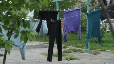Temiz giysiler ve çarşaflar çamaşır ipine asılarak çok katlı bir binanın bahçesindeki sokaklarda kurumaya bırakıldı. Şiddetli rüzgar