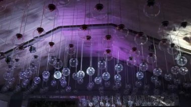 Tavanın altında bir sürü yuvarlak avize ve lamba var. Işık gösterisi lambaları karanlık moda iç mekan, aydınlatma ve iç mekan konsepti.