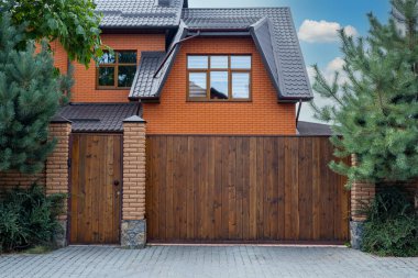 İşlenmiş demir elementlerle dolu ahşap kapı yerleşim yerinin yakınında..