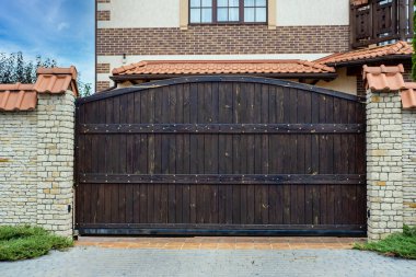 İşlenmiş demir elementlerle dolu ahşap kapı yerleşim yerinin yakınında..