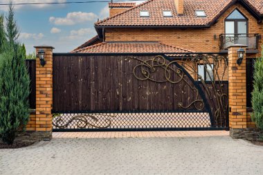 İşlenmiş demir elementlerle dolu ahşap kapı yerleşim yerinin yakınında..