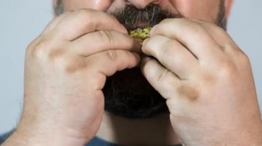 Yakın plan, sakallı adam yer, fast food, flüt.