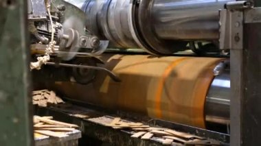 Kesme makinesi, karton kağıtlardan karton kutular çıkarıyor. Yakın çekim, karton kutu üretiminde atık. Oluklu Karton Kutu Fabrikası.