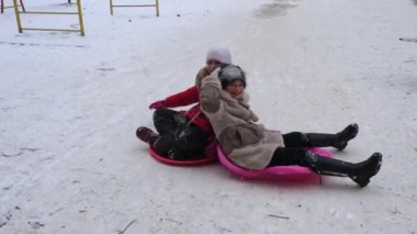 Ukrayna. Vinnytsia, 2021 dolaylarında. Çocuklar için kış Noel eğlencesi. Çocuklar buz kaydırağına biniyor. Kış oyunları, spor, eğlence ve eğlence konsepti