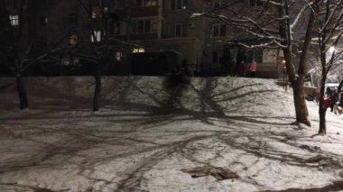 Çocuklar için kış Noel eğlencesi. Çocuklar akşamları buz kaydırağına biniyorlar. Kış oyunları, spor, eğlence ve eğlence konsepti