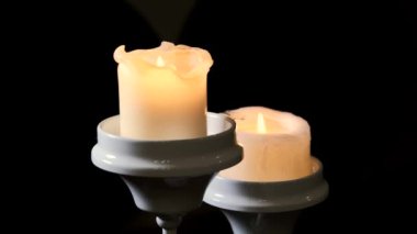 Bir şamdanın üzerinde yanan iki mumu söndürüyordum..