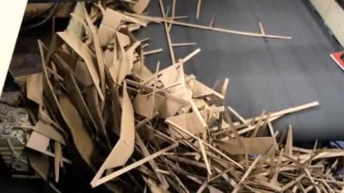 Kesici atıklar. Kağıt kırıntıları kapanıyor, karton kutuların üretiminde atıklar var. Karton kutu üretimi. Sesli çekim. Kart tahtası kağıdından geri dönüşüm kavramı.