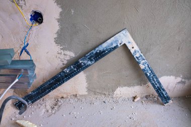 Kirli duvar arkaplanındaki kirli üçgen cetvel.