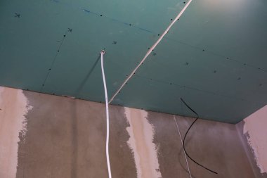 Onarım. Kablolu yeşil alçıpan tavanı.