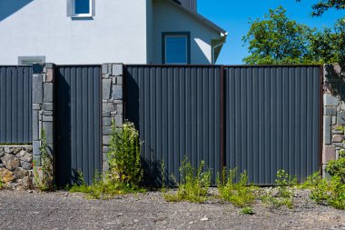 Konut binasının önündeki gri metal kıvrımlı çit. Profilli metalin dokusu.