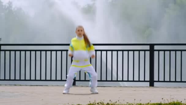 Şık Takım Elbiseli Küçük Bir Kız Çeşmenin Arka Planında Hip — Stok video