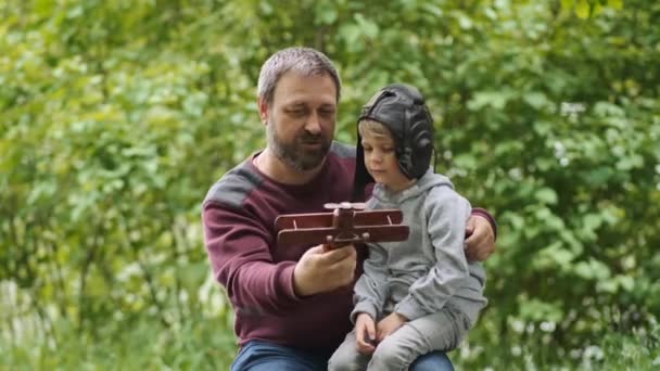 Skäggig Far Och Son Leker Med Ett Leksaksflygplan Trä Naturen — Stockvideo