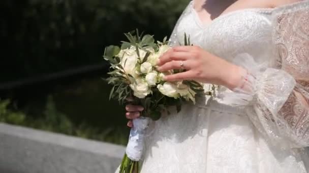 公園できれいな花嫁の手の中に美しい結婚式の花束のクローズアップ 結婚式の日 婚約は — ストック動画