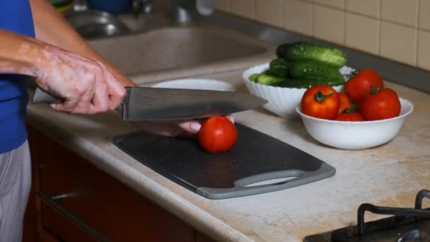 Enfermedad del vitiligo en manos de una joven. despigmentación de las zonas de la piel. Una mujer corta tomates rojos con un cuchillo en la cocina. — Vídeos de Stock