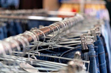 Üzerinde kot pantolon olan metal bir askıya yakın çekim görüntüsü.