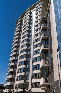 Birçok penceresi ve balkonu olan yüksek modern bir bina.