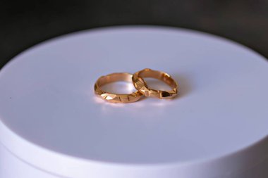 Beyaz bir yüzeyde iki altın yüzük