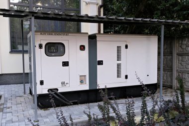 Siyah kapısı ve dijital ekranı olan beyaz bir dizel jeneratör.