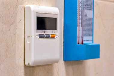 Termometrenin yanındaki duvarda bir termostat.