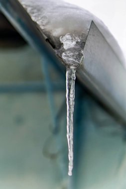 Arabanın kenarından sarkan buz saçakları.