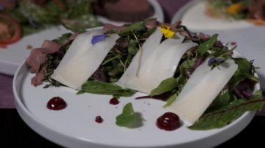 Üstünde salata olan beyaz bir tabak.