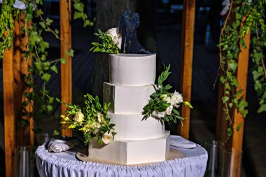 Üstünde gelin ve damat heykeli olan bir düğün pastası.