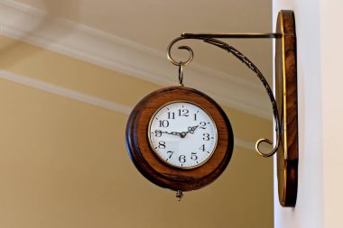 Duvarda asılı beyaz bir yüzü olan tahta bir saat...