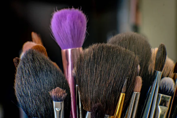 Çeşitli kıllı renk ve dokulara sahip makyaj fırçaları koleksiyonunun yakın çekimi.