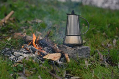 Ormanda çaydanlık ve çaydanlık yanıyor.