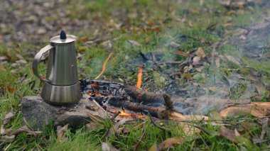 Ormanda yerde ateş ve su ısıtıcısı