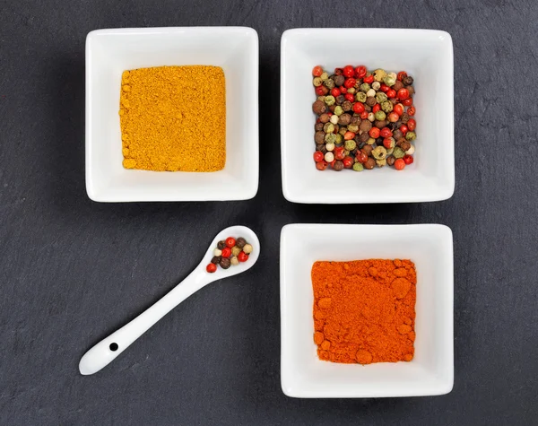 Saffron, curry and allspice on a slate board — Stock Photo, Image