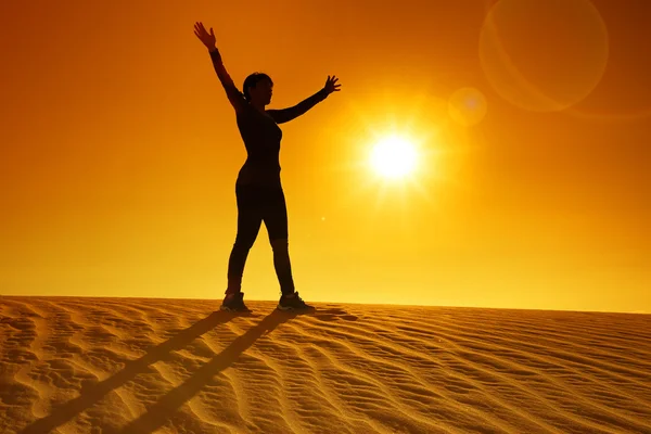 Woman with outstretched arms on top of a dune — Stock Photo, Image