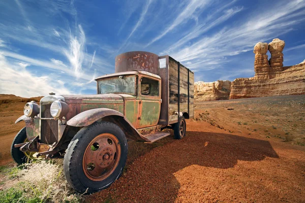 Camion abbandonato arrugginito in un paesaggio roccioso del deserto — Foto Stock