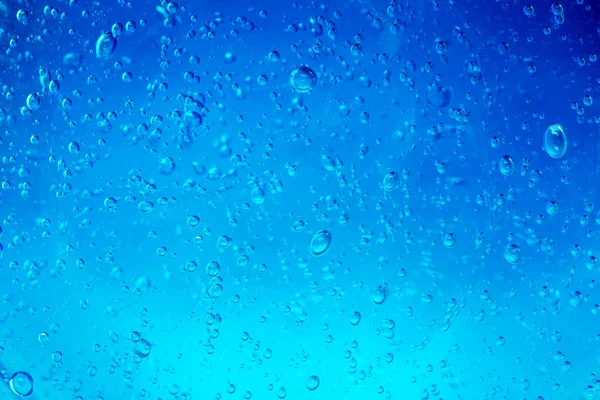 青色の背景に流れる水の気泡 — ストック写真