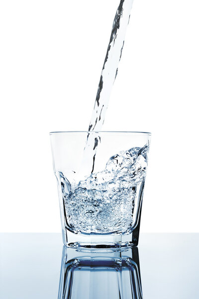 fresh water filling a glass isolated on white