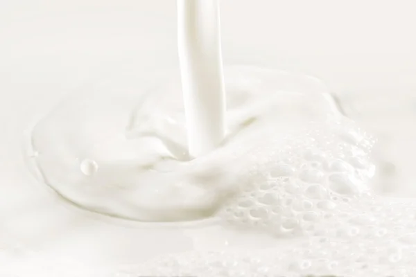 Close up of poured fresh milk and bubbles — Stock Photo, Image