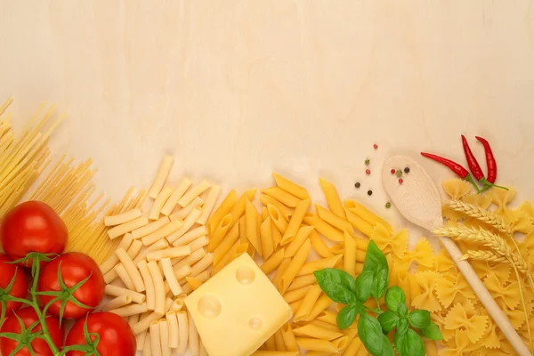 Variedades de pasta, queso y tomates sobre tabla de madera — Foto de Stock