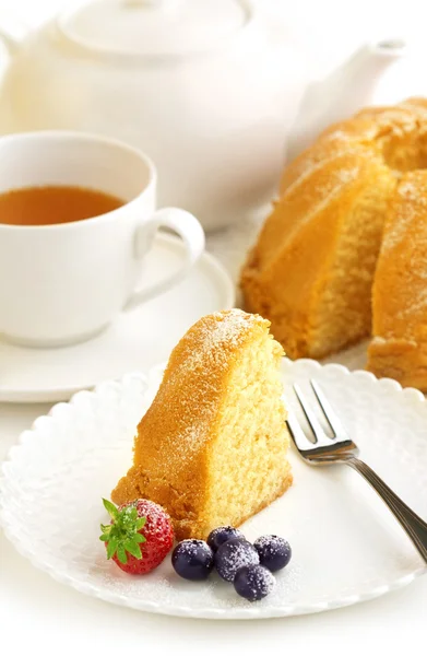 Slice of donut, cup of tea and teapot — Stock Photo, Image