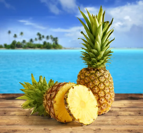 Pineapple on wooden table in a tropical landscape