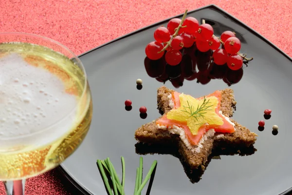 Smoked salmon canapé and glass of champagne — Stock Photo, Image