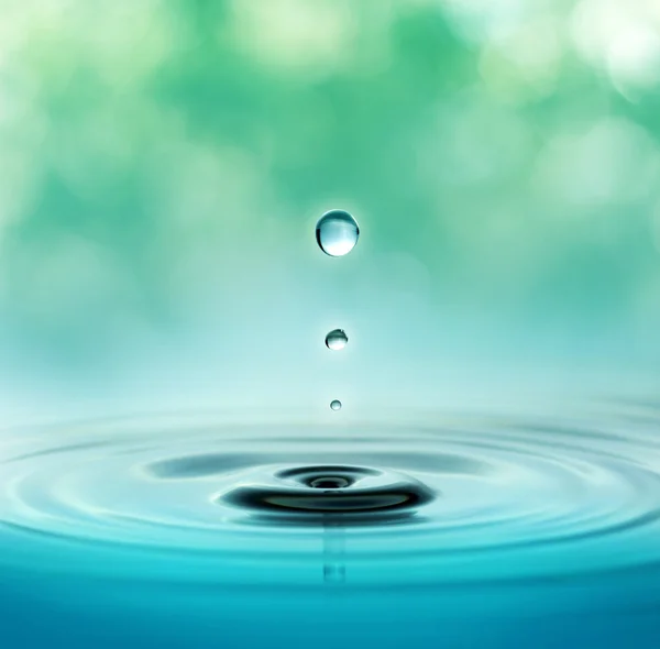 Close up of three droplets in a blurred green background — Stock Photo, Image