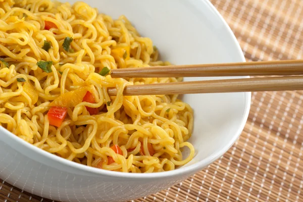 Close-up van bamboe stokjes houden vegetarische noedels — Stockfoto