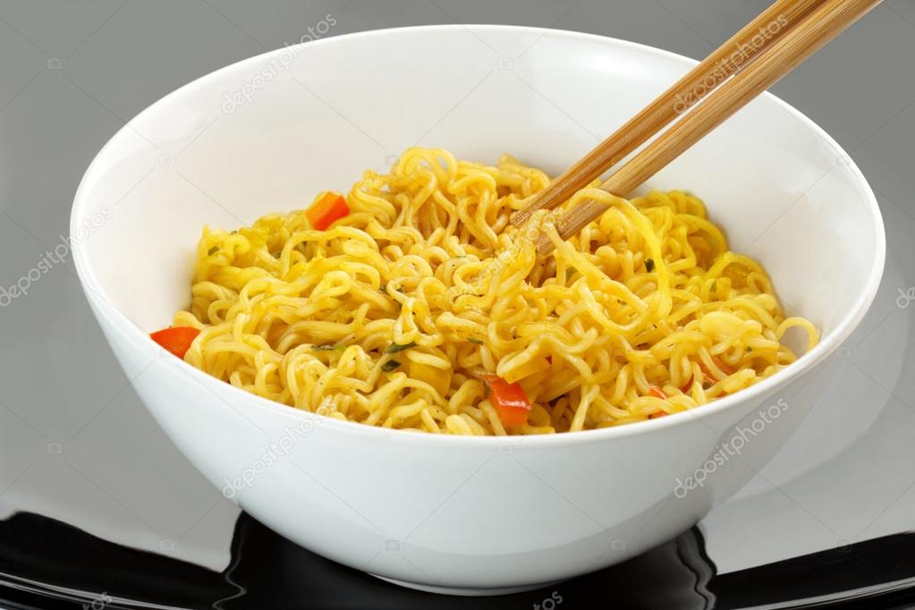 Vegetarian noodles and chopsticks on black background
