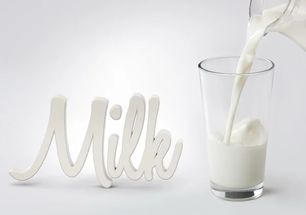Mleko przelewa się w szkło i słowo "milk" — Zdjęcie stockowe