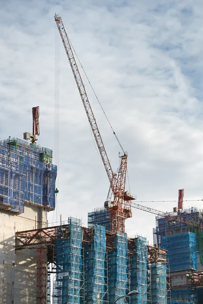 Cranes and scaffoldings in a construction site — Stock Photo, Image