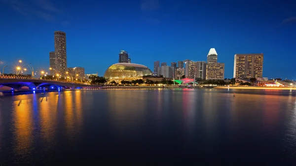 Bridge, skyscrapers and waterfront illuminated by night — Stock Photo, Image